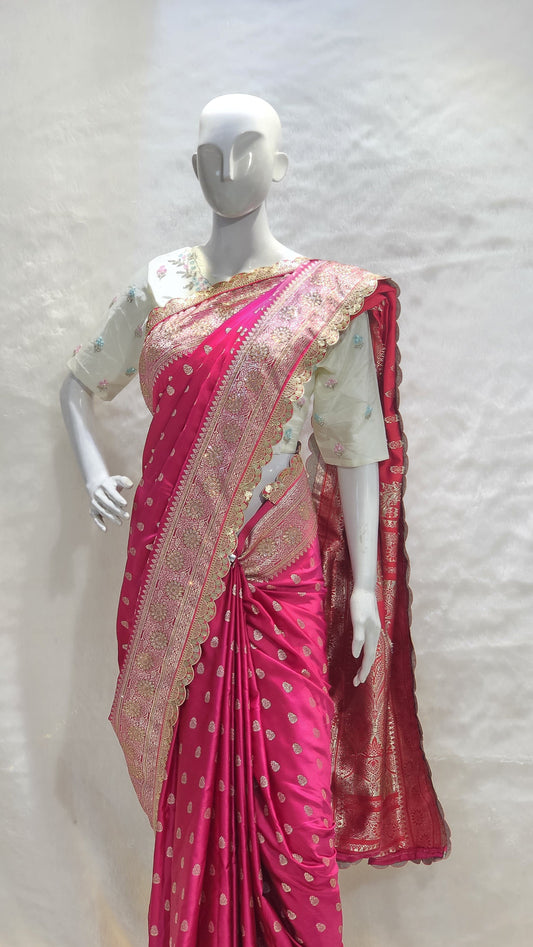 Graceful silver zari buttis all over a classic pink Banarasi base give this saree a festive sparkle with a refined cutwork border.