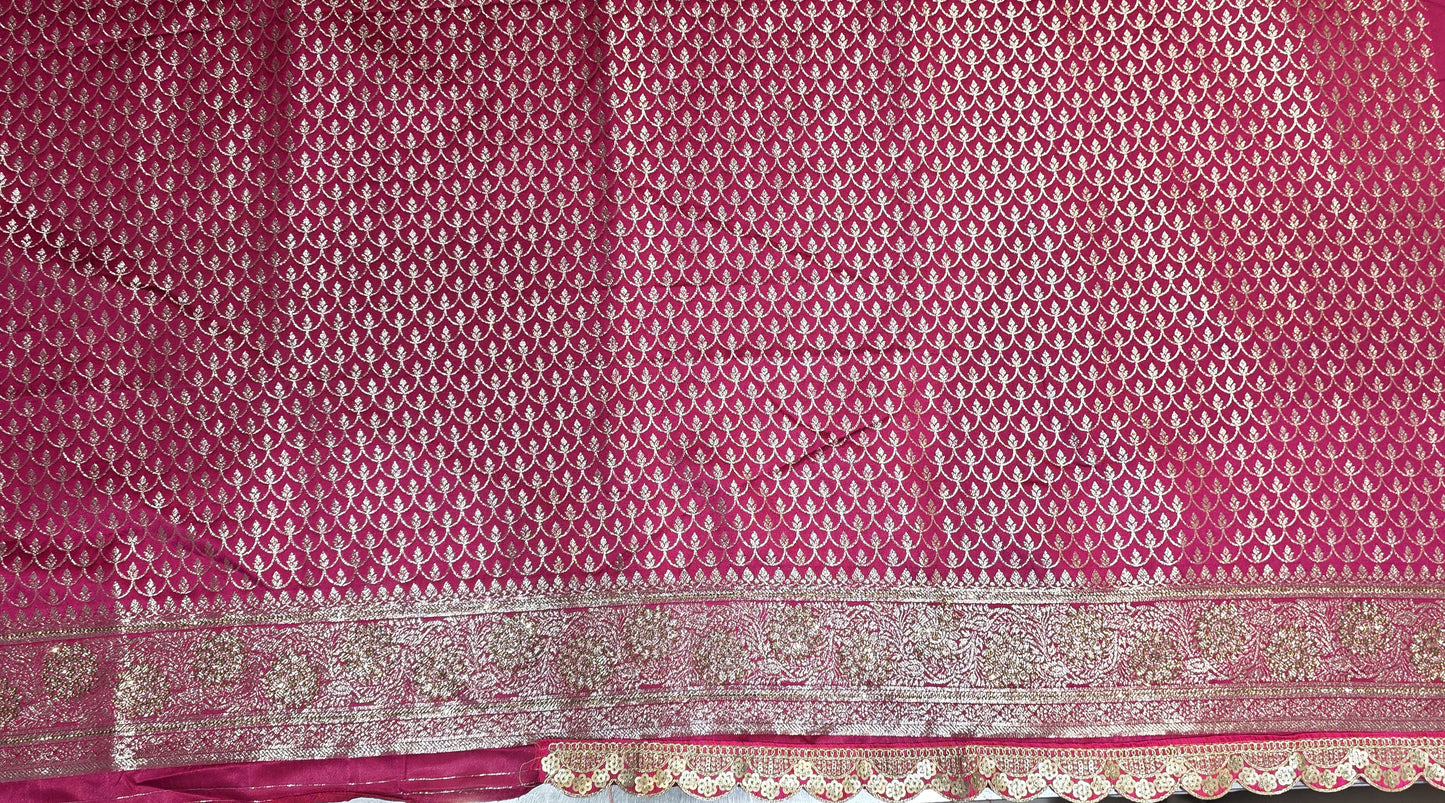 Graceful silver zari buttis all over a classic pink Banarasi base give this saree a festive sparkle with a refined cutwork border.