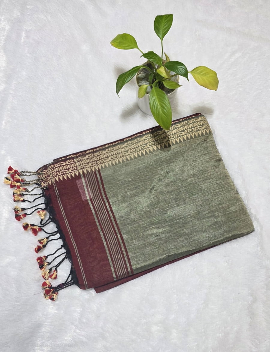 Festive maroon pure cotton saree with intricate butti pattern, copper zari pallu, and classic golden border and tassels.
