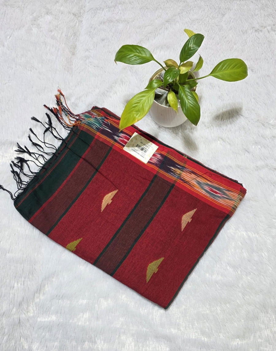 Traditional bottle green cotton saree designed with triangle butti work, Ikat woven border, stylish contrast pallu with tassels, breathable saree for all-day comfort.