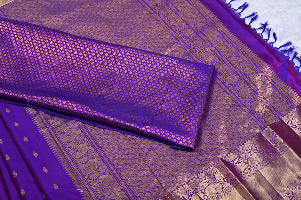 Close-up of a purple fabric with intricate patternsMagenta Pure Kanchi Silk Saree with Golden Butti and Border