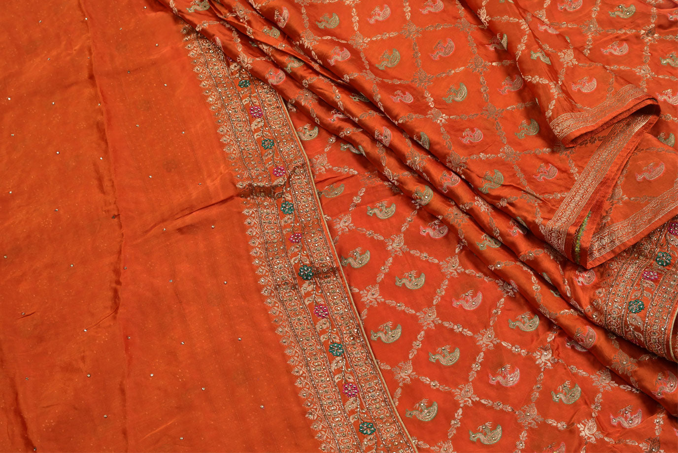 Orange fabric with intricate patterns and embroidery