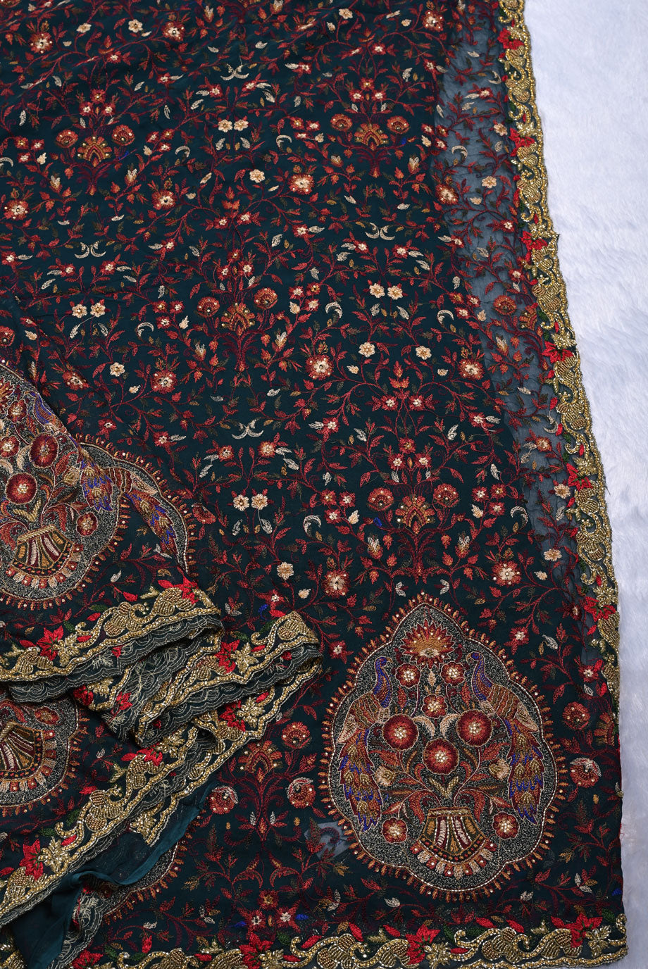 Close-up of a patterned fabric with intricate designs on a dark background