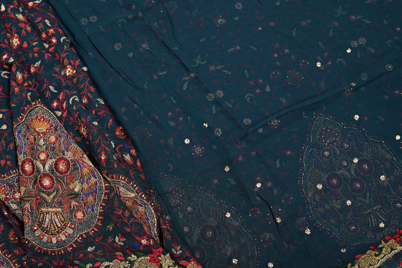 Close-up of a dark blue fabric with intricate patterns and embellishments.