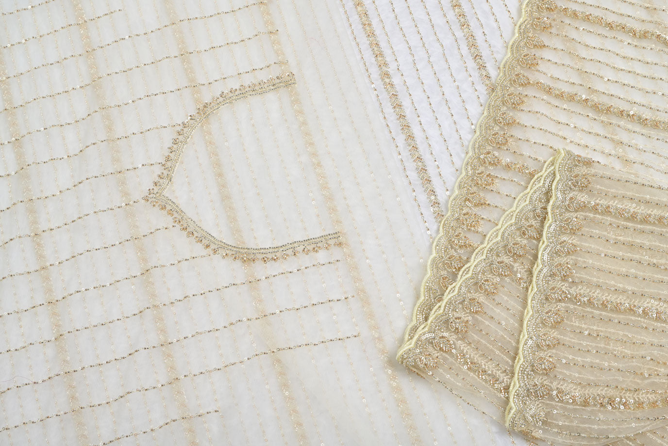Close-up of textured fabric with intricate patterns on a light Fabric eyevery organza saree for weddings and festive occasionsbackground