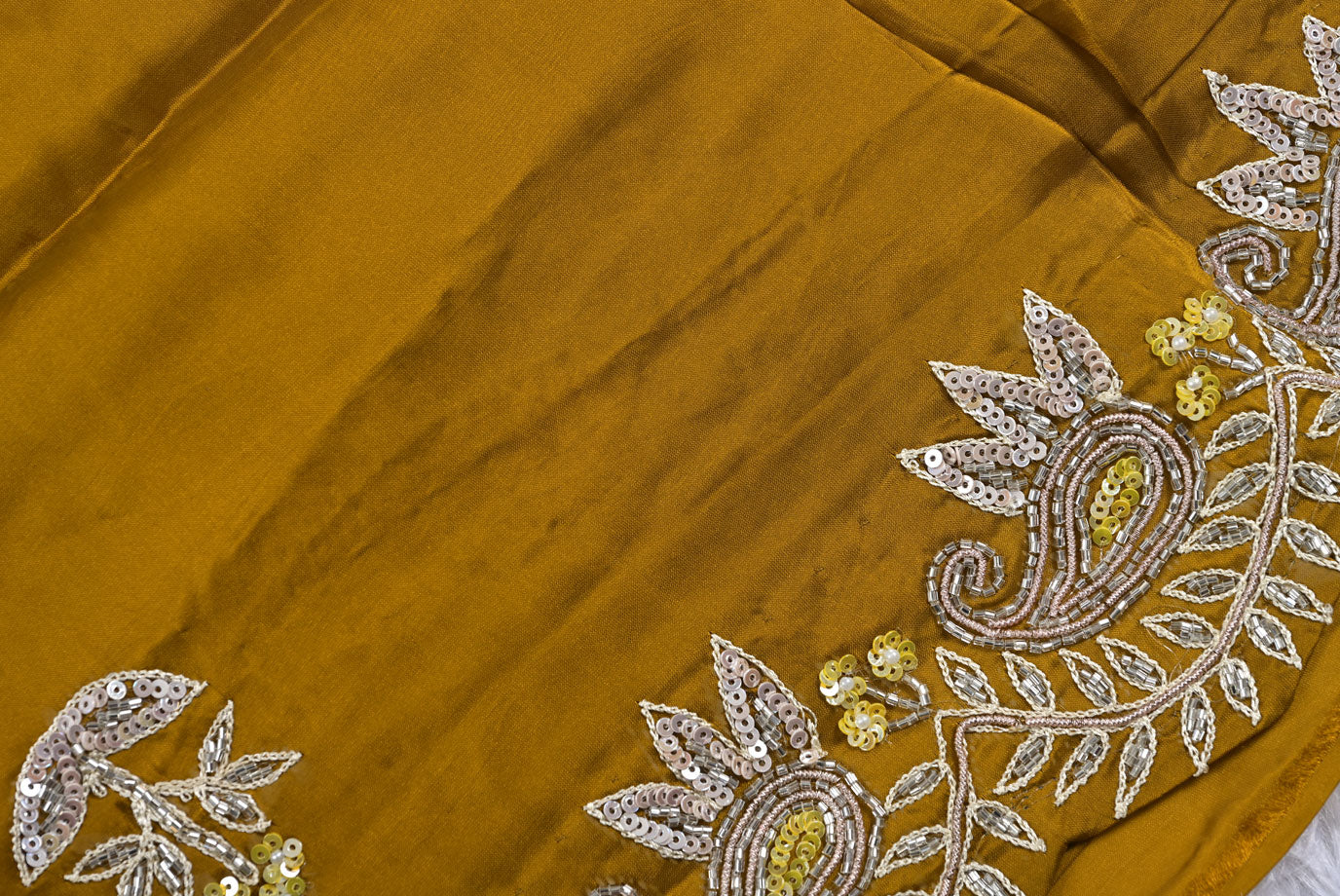 Mustard yellow fabric with intricate silver and gold embroidery