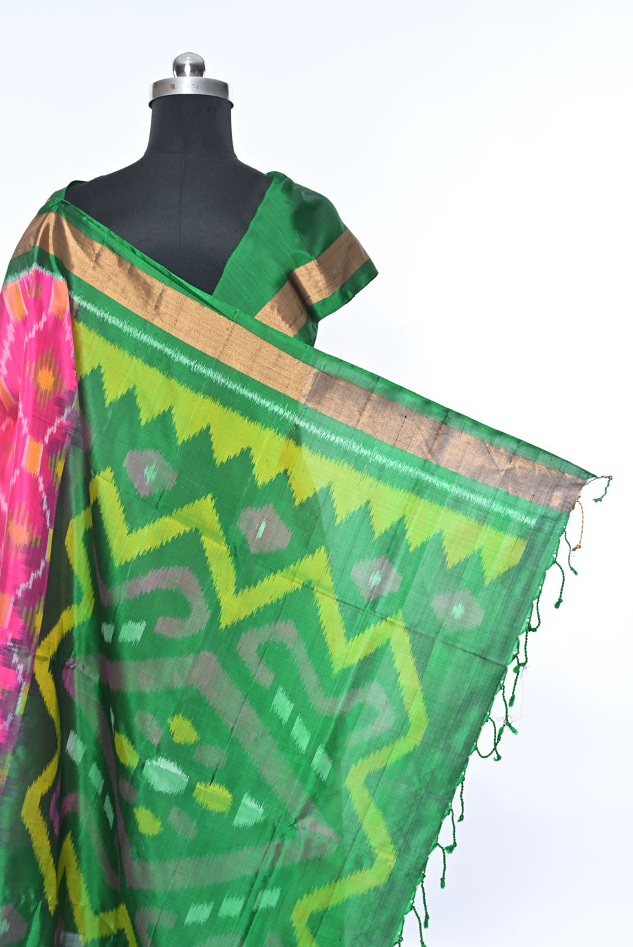 Green saree with pink and yellow patterns on a mannequin against a white background green colour pure soft silk saree for weddings and festive occasions