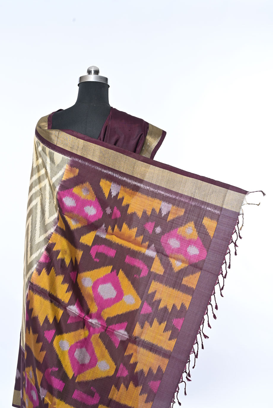 Saree with geometric pattern on a mannequin against a white ,Silk wine colour pure soft silk saree for weddings and festive occasionsbackground