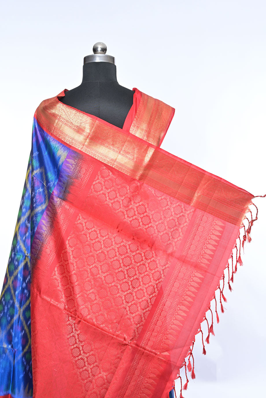 Red and blue patterned fabric on a mannequin with a white background Silk red pure soft silk saree for weddings and festive occasions