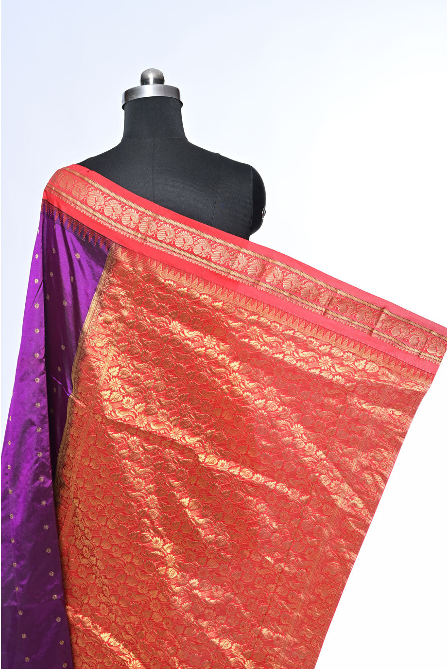 Red saree with gold border on a mannequin against a white Silk gadhval silk saree for weddings and festive occasionsbackground