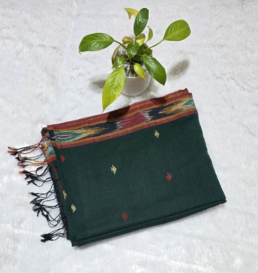 Elegant bottle green cotton saree featuring triangle butties, traditional Ikat border weaving, contrast pallu with tassels, lightweight saree for summer and festive wear.