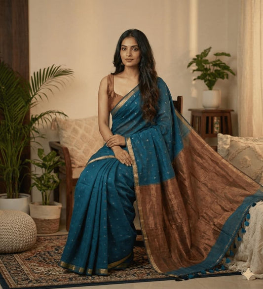 This teal blue cotton saree comes with overall small butties, minimal border, rich copper zari pallu with elegant tessels ideal for everyday use, office wear , casual wear .