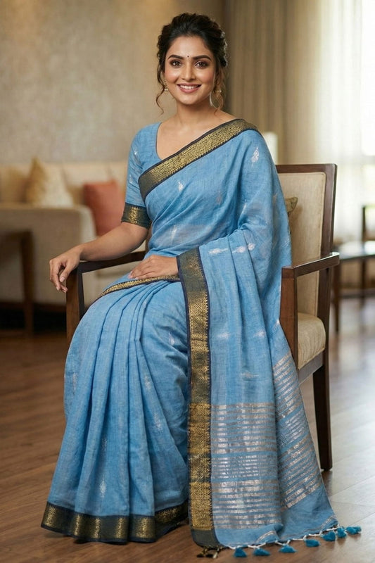 Soft sky blue cotton saree featuring silver butti design, golden striped pallu, and classic golden edge border.