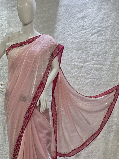 A luxurious baby pink pure satin silk saree adorned with delicate overall small stone work that gives a subtle festive sparkle. The saree is elevated with a contrast dark pink border, embellished with matching stone handwork, adding richness and definition to the drape. Paired with a dark pink contrast blouse, this saree is perfect for weddings, receptions, and special gatherings where timeless elegance is desired.