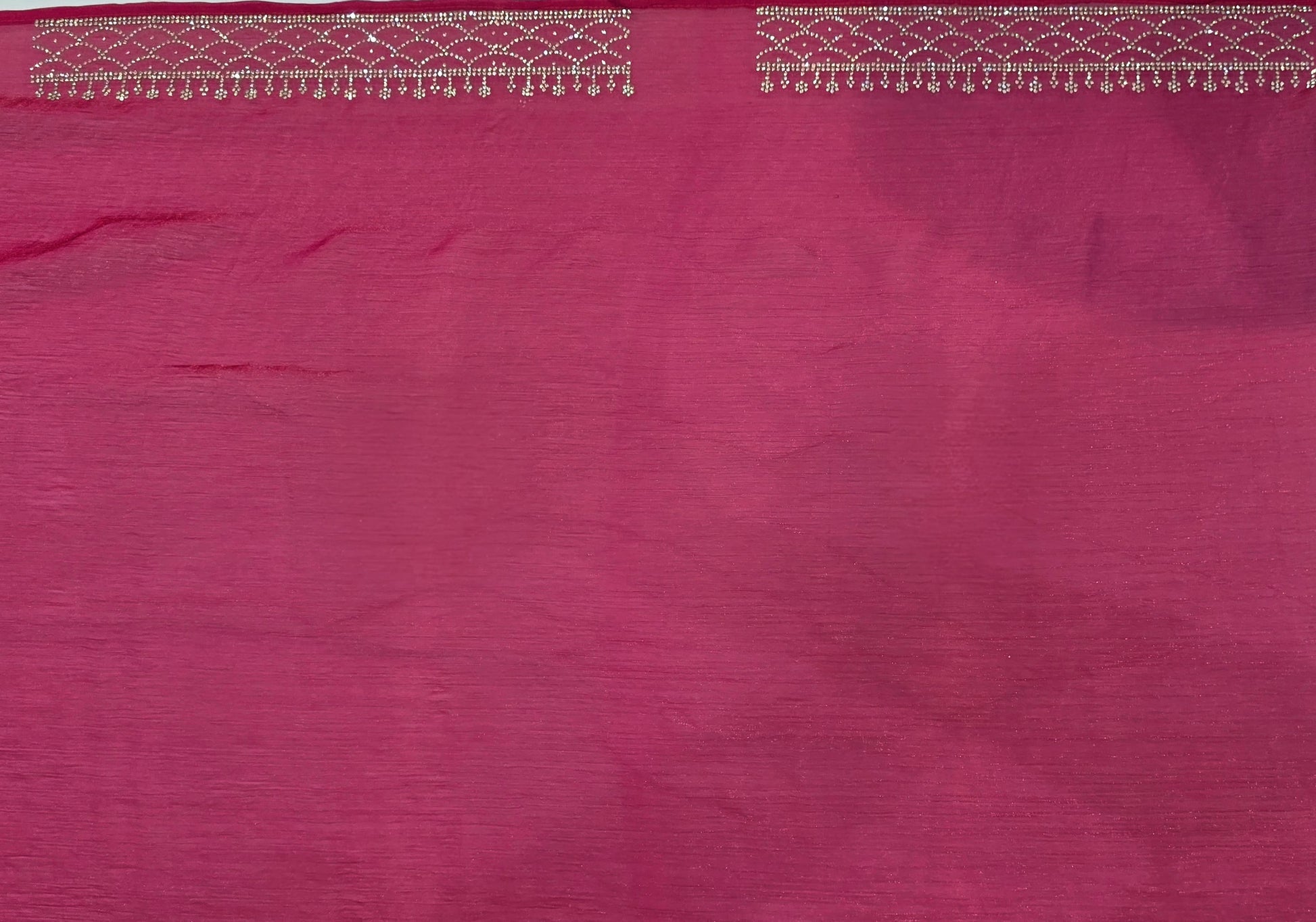 A luxurious baby pink pure satin silk saree adorned with delicate overall small stone work that gives a subtle festive sparkle. The saree is elevated with a contrast dark pink border, embellished with matching stone handwork, adding richness and definition to the drape. Paired with a dark pink contrast blouse, this saree is perfect for weddings, receptions, and special gatherings where timeless elegance is desired.