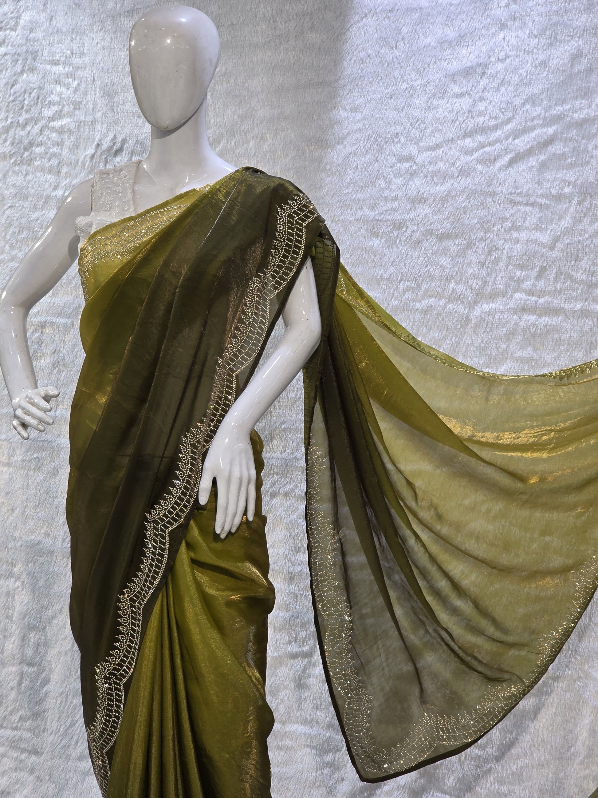 A contemporary neon and bottle green pure satin silk saree featuring a plain body paired with a heavy stone-work necklace border, creating a stunning contrast. The rich border detailing adds a designer edge, while the running blouse maintains a coordinated look. This saree is perfect for pre-wedding functions, mehendi events, and fashionable festive wear.