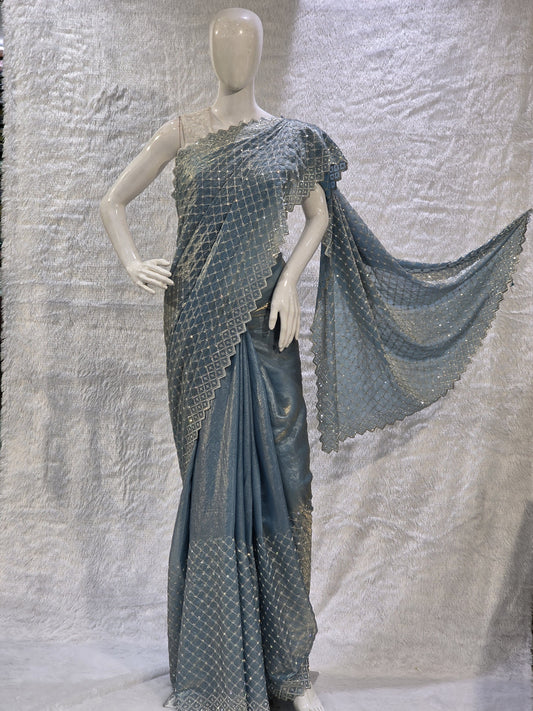 A vibrant sky blue pure satin silk saree embellished with sharp heavy stone work across the body, giving it a bright and festive shine. The saree comes with a running sky blue blouse for a seamless monochrome designer look. Its subtle elegance and rich shine make it perfect for festive events, haldi functions, and celebrations.