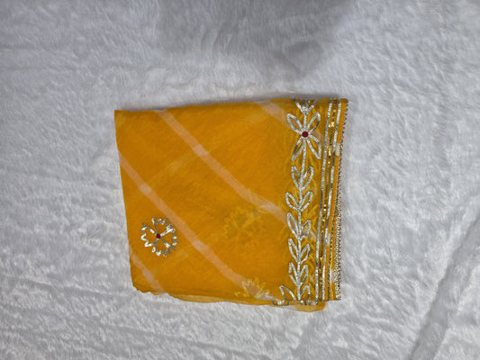 A bright and cheerful organza saree styled with leheriya pattern and gold gota patti border. Festive, light and elegant — great for haldi ceremonies. Teamed with a self blouse for a complete look.