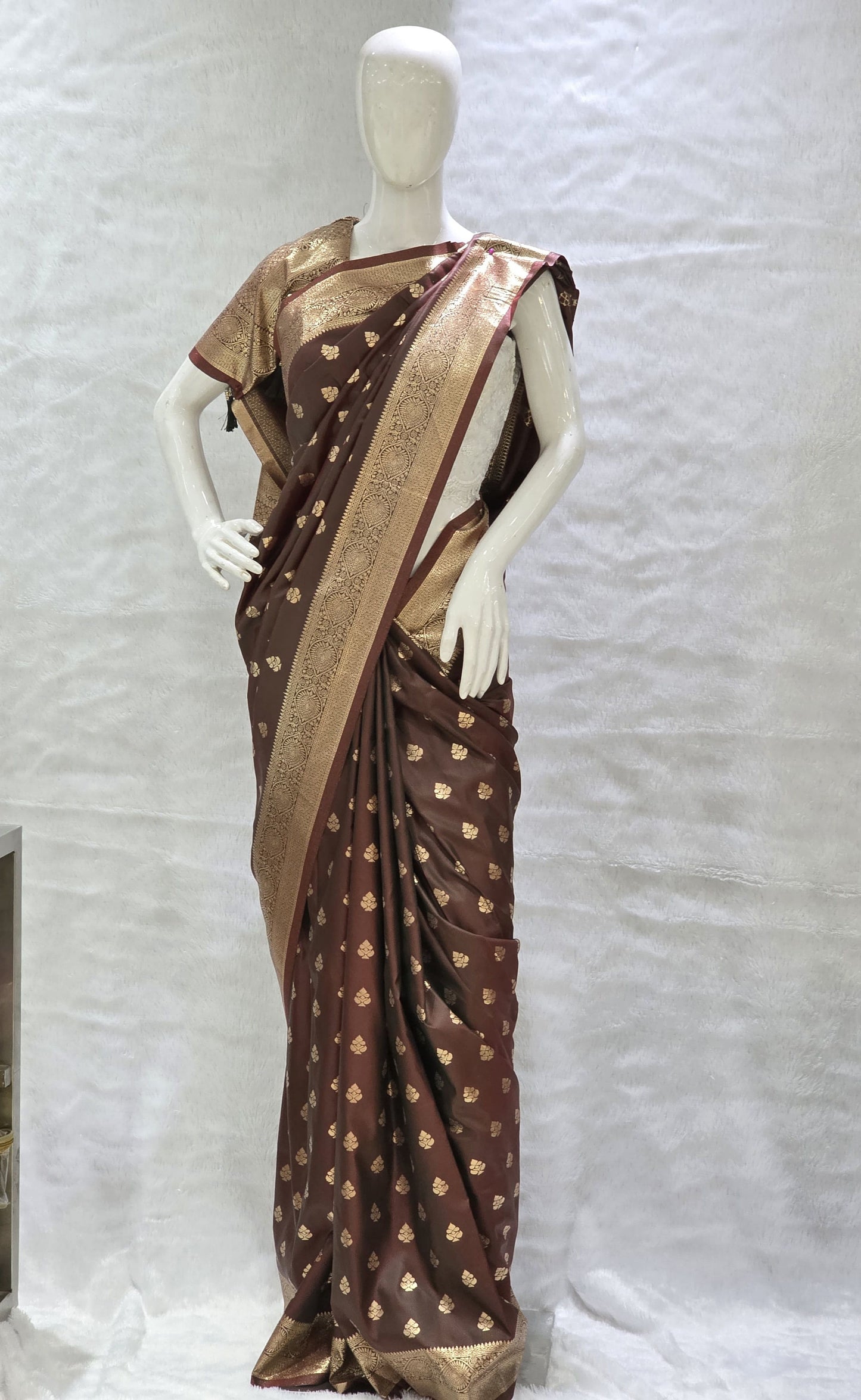 Crafted in tana silk, this saree showcases allover delicate gold zari buttis paired with a rich paithani pallu. Lightweight yet regal, perfect for pujas and family functions. Includes a matching self blouse.
