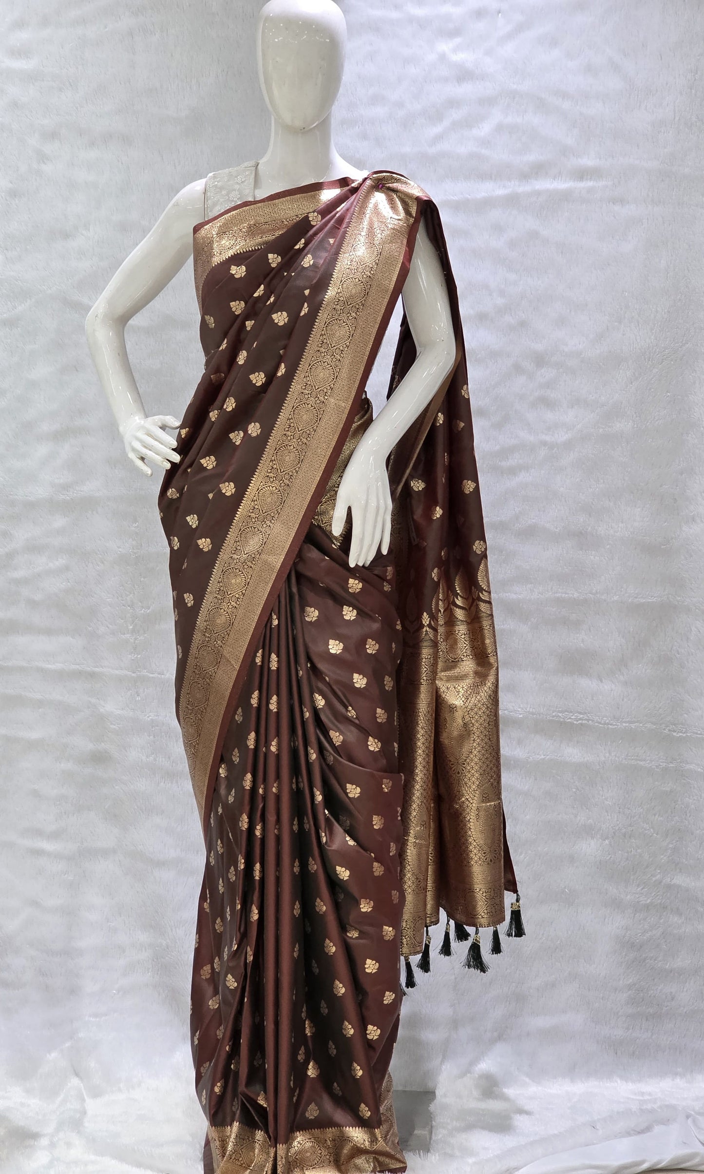 Crafted in tana silk, this saree showcases allover delicate gold zari buttis paired with a rich paithani pallu. Lightweight yet regal, perfect for pujas and family functions. Includes a matching self blouse.
