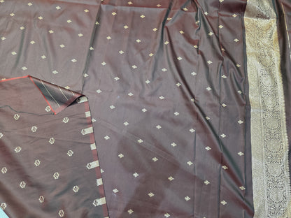 Crafted in tana silk, this saree showcases allover delicate gold zari buttis paired with a rich paithani pallu. Lightweight yet regal, perfect for pujas and family functions. Includes a matching self blouse.