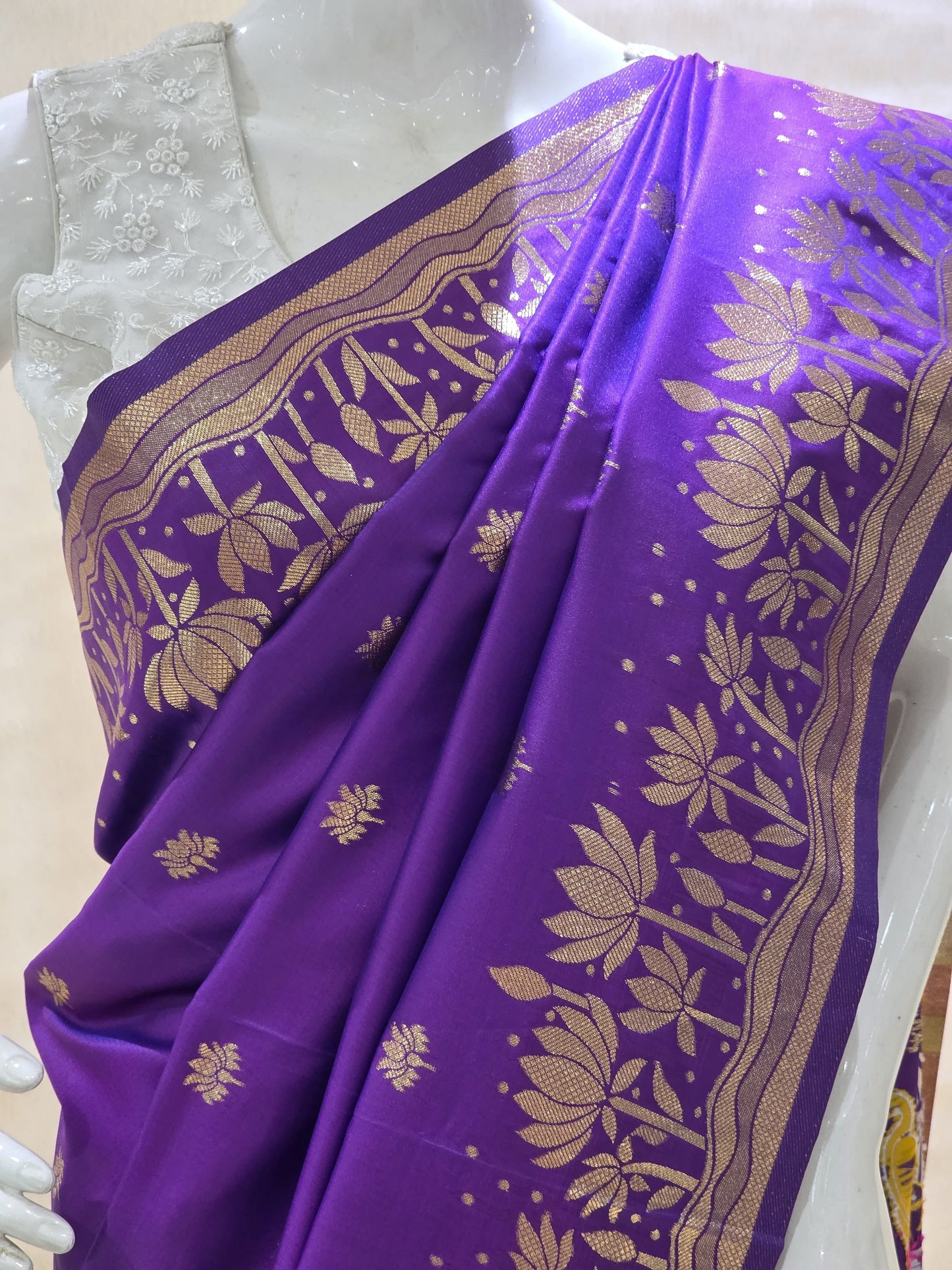 A rich tana silk paithani saree featuring evenly spaced lotus buttis woven in golden zari. The floral lotus border and traditional rich pallu elevate its classic charm. Comes with a self blouse for a graceful traditional look.