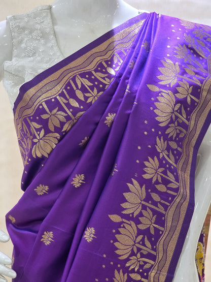 A rich tana silk paithani saree featuring evenly spaced lotus buttis woven in golden zari. The floral lotus border and traditional rich pallu elevate its classic charm. Comes with a self blouse for a graceful traditional look.