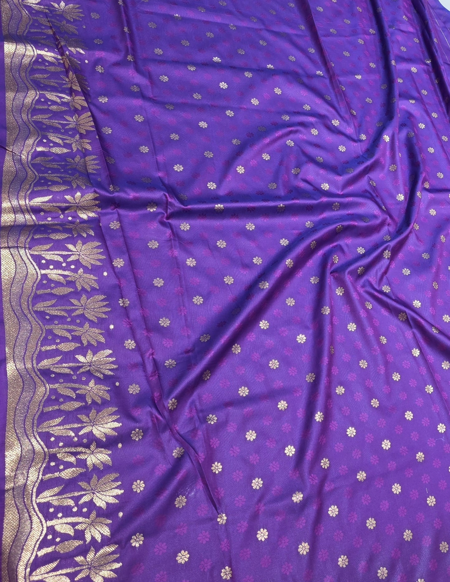 A rich tana silk paithani saree featuring evenly spaced lotus buttis woven in golden zari. The floral lotus border and traditional rich pallu elevate its classic charm. Comes with a self blouse for a graceful traditional look.