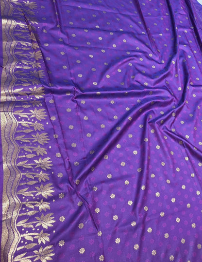 A rich tana silk paithani saree featuring evenly spaced lotus buttis woven in golden zari. The floral lotus border and traditional rich pallu elevate its classic charm. Comes with a self blouse for a graceful traditional look.