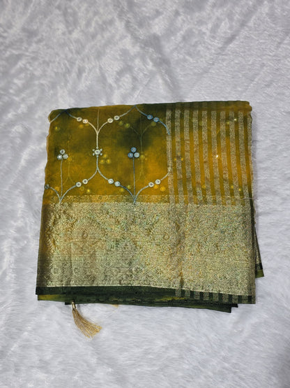 An intricate organza gotapatti  saree featuring allover shimmering accents, sequins/mirror-like detailing and traditional gota patti lace border. Lightweight yet festive, perfect for family occasions. Comes with a self blouse in matching tone.