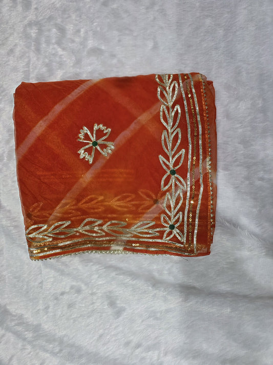 A vibrant organza saree featuring a classic leheriya pattern and rich gold gota patti border. Lightweight, festive and eye-catching — perfect for haldi, mehendi and small functions. Comes with a matching self blouse.