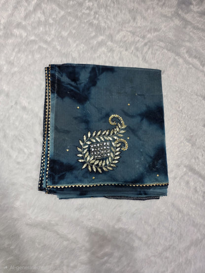 A Gotapatti  organza saree crafted with elegant gota patti work, highlighted with scattered sequins for a subtle shimmer. Dual-tone teal and deep blue color palette adds richness and uniqueness. Completed with a matching self blouse.