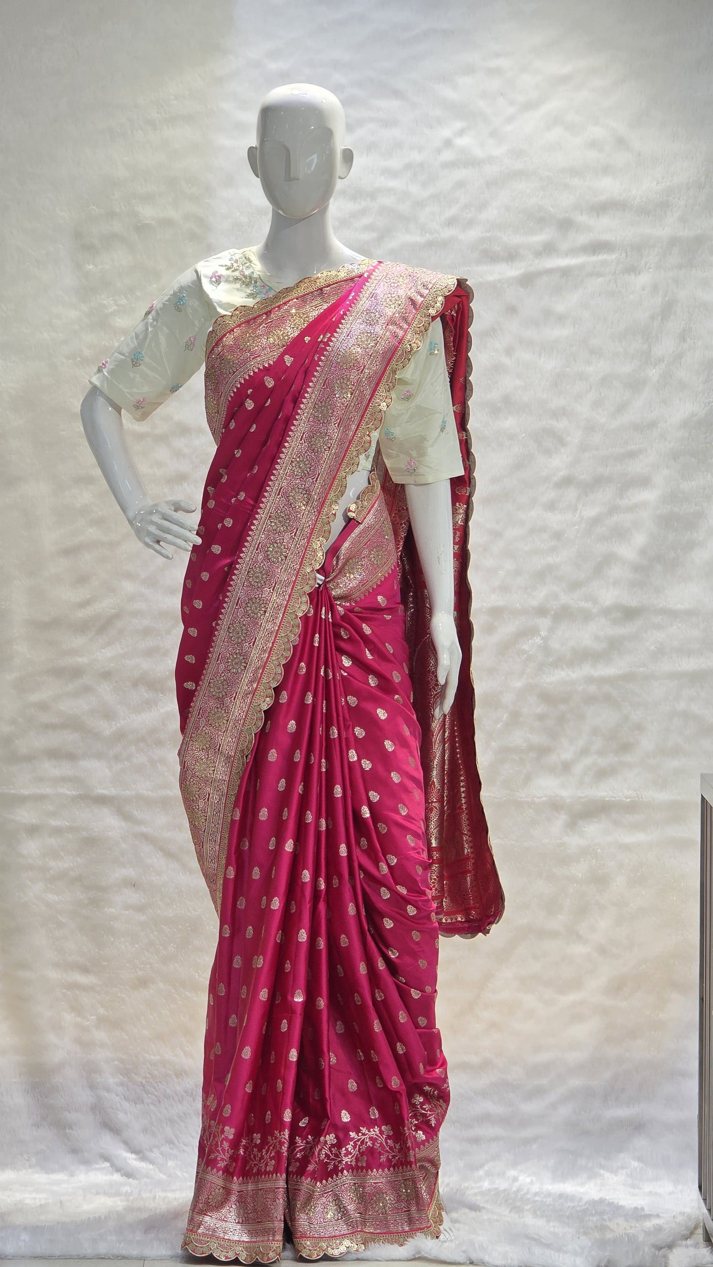 Graceful silver zari buttis all over a classic pink Banarasi base give this saree a festive sparkle with a refined cutwork border.