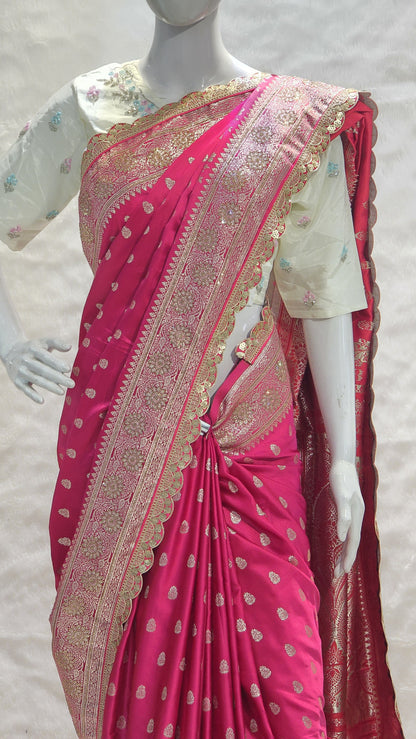 Graceful silver zari buttis all over a classic pink Banarasi base give this saree a festive sparkle with a refined cutwork border.