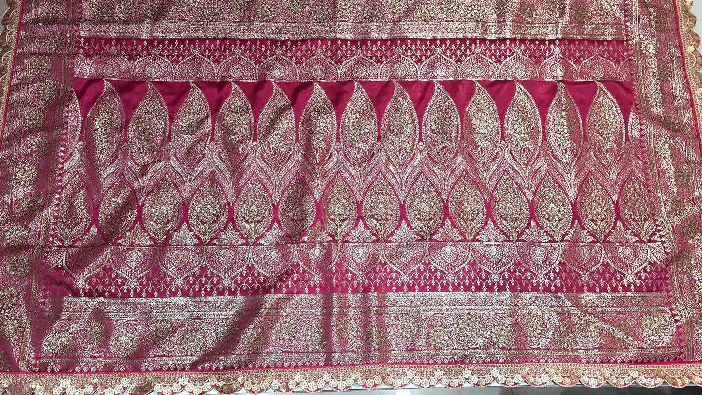 Graceful silver zari buttis all over a classic pink Banarasi base give this saree a festive sparkle with a refined cutwork border.