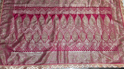 Graceful silver zari buttis all over a classic pink Banarasi base give this saree a festive sparkle with a refined cutwork border.