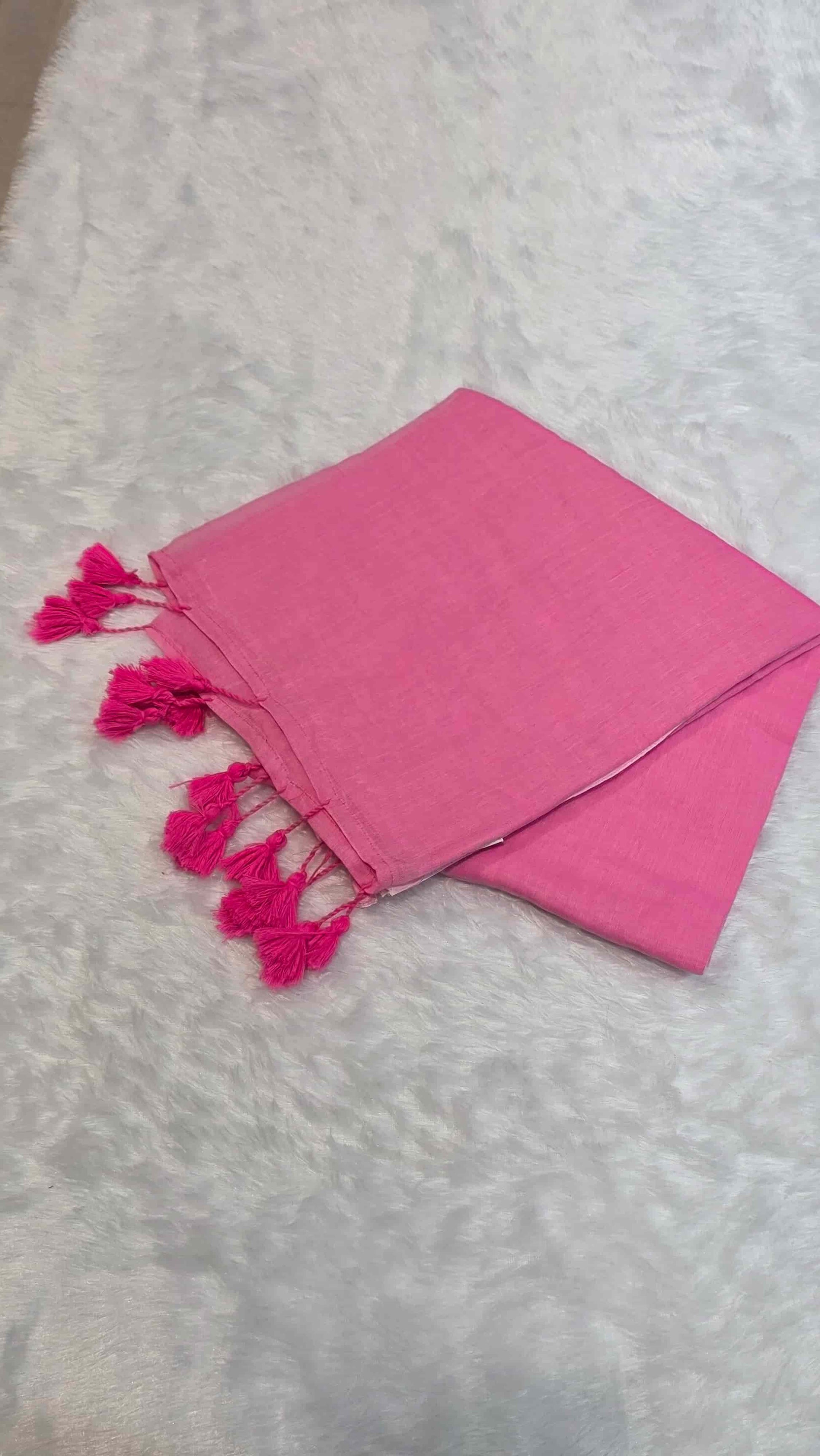 Bright pink cotton saree with subtle borders, self-blouse pattern, and tassels for office look.