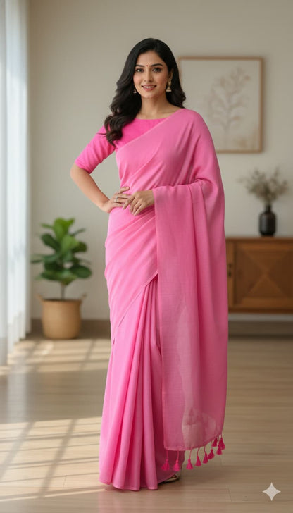Bright pink plain cotton saree with self-blouse design, minimal borders, and tassels for office wear.