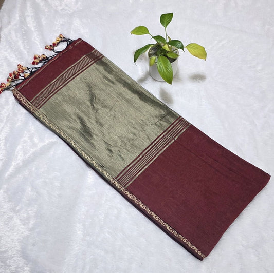 Ethnic maroon cotton saree featuring butti design, rich copper zari pallu, golden edge border, and tassel detailing.