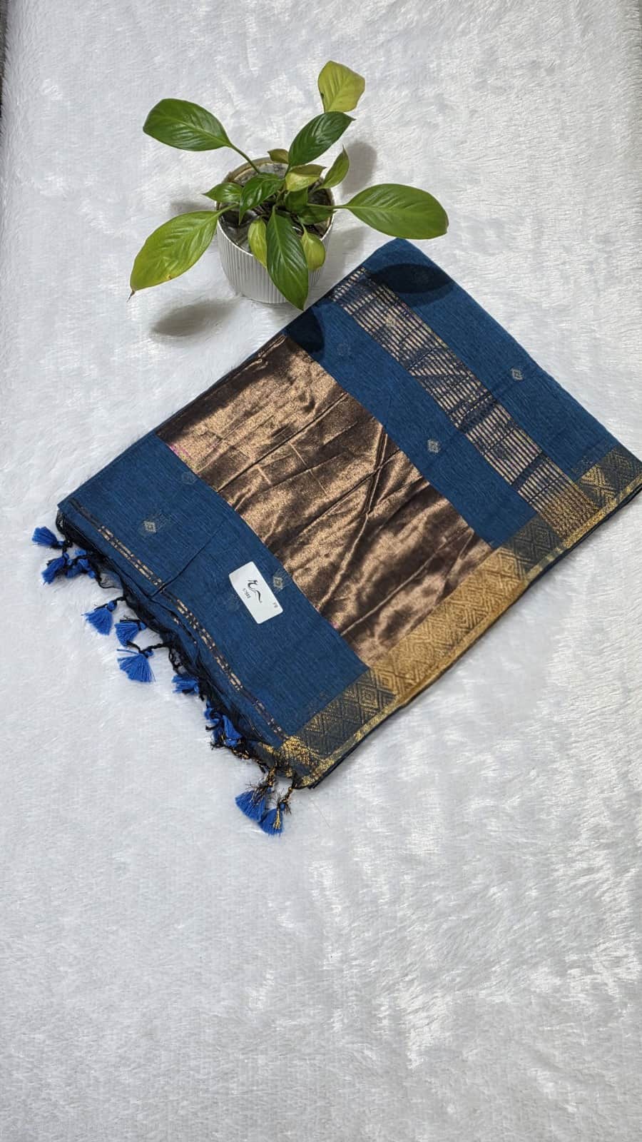 Elegant teal blue cotton saree adorned with copper butti weaving, zari pallu, and graceful golden edge.