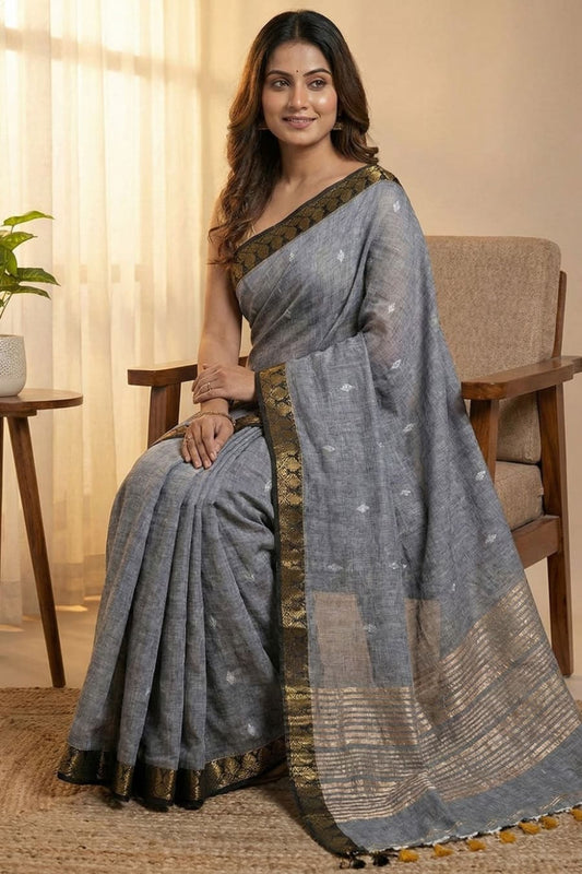 Gray pure cotton saree with all over silver butti work, golden line stripes at the pallu and golden border ideal for alll day and office work