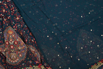 Close-up of a dark blue fabric with intricate patterns and embellishments.