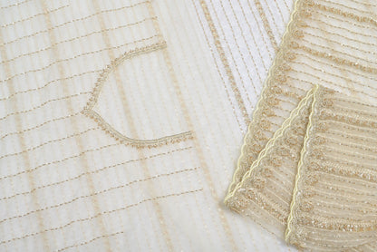 Close-up of textured fabric with intricate patterns on a light Fabric eyevery organza saree for weddings and festive occasionsbackground