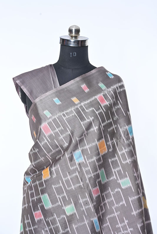 Gray saree with colorful geometric pattern on a mannequin against a white background