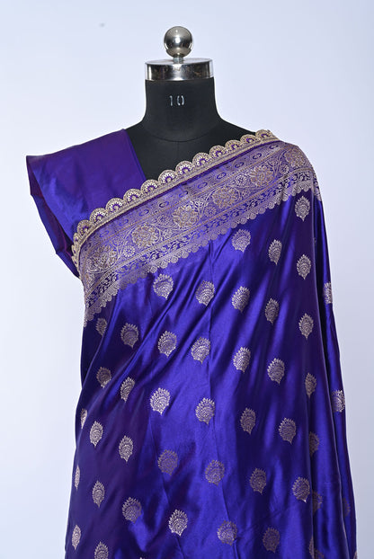 Blue saree with gold patterns on a mannequin against a white background
