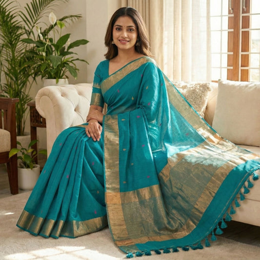 Teal blue cotton saree woven with colourful triangle butti patterns, copper zari pallu work and minimal golden border with tassels