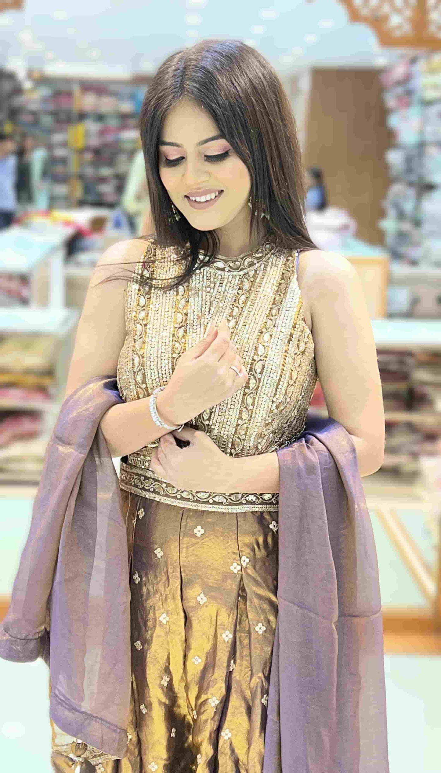 Wide-leg pleated palazzo pants of antique bronze metallic jumpsuit showcasing lehenga-inspired silhouette.