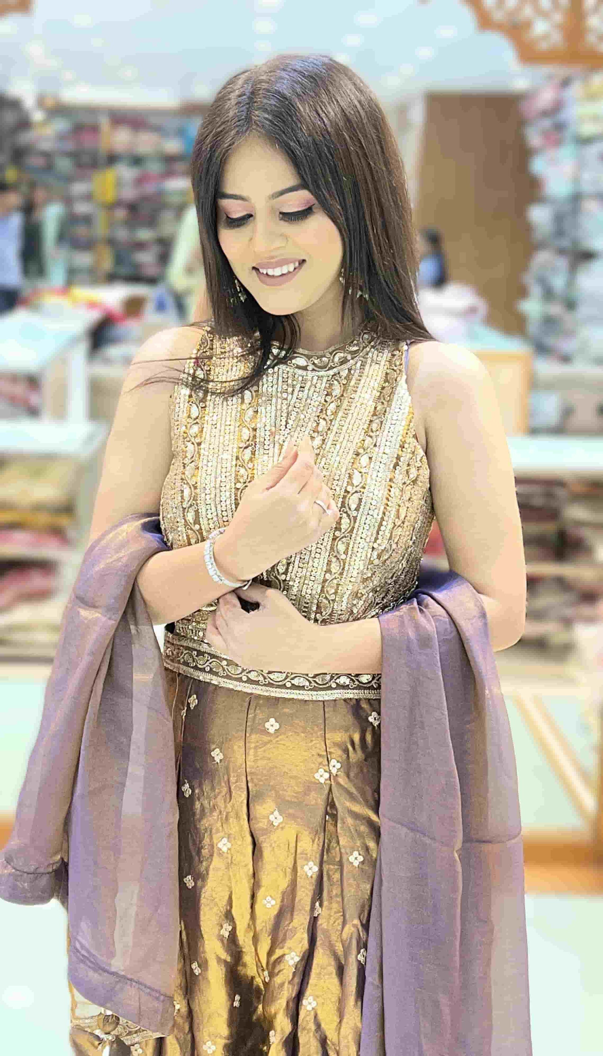 Wide-leg pleated palazzo pants of antique bronze metallic jumpsuit showcasing lehenga-inspired silhouette.