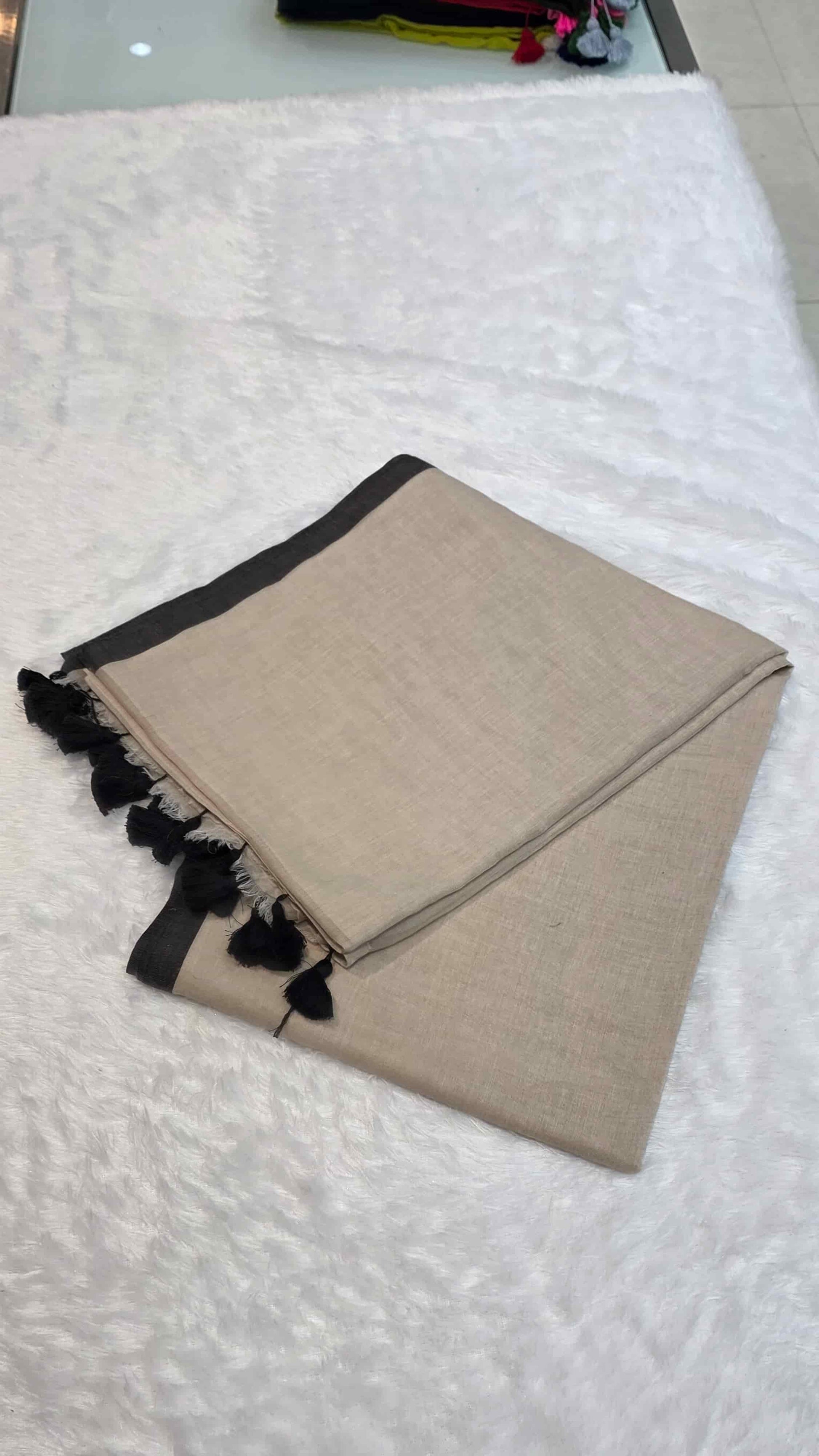 Elegant beige mulmul cotton saree with hand-tied tassels on pallu