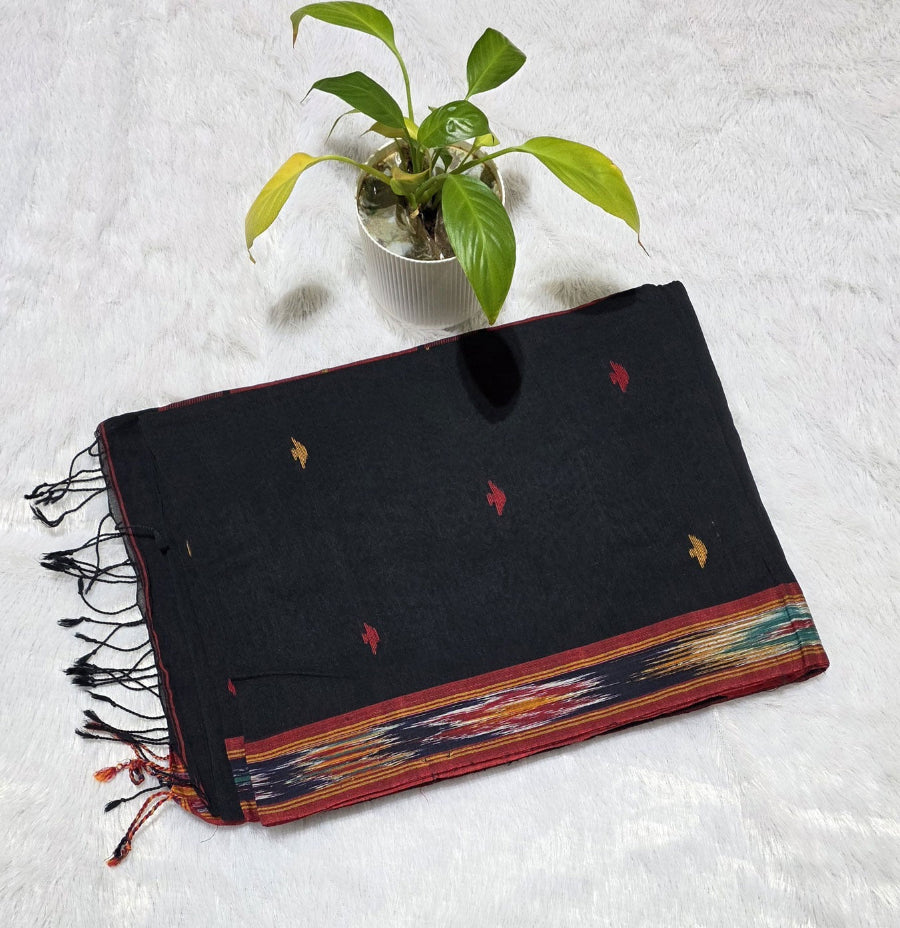 Black cotton saree with small triangle butti pattern, Ikat border weaving, contrast pallu styling and tassel detailing